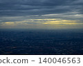 Looking through the airplane window with the view of cityscape under the clouds. Clouds above the city. Looking from aerial view. Nature and travel concept. 140046563