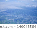 Looking through the airplane window with the view of cityscape under the clouds. Clouds above the city. Looking from aerial view. Nature and travel concept. 140046564