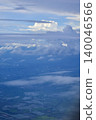 Looking through the airplane window with the view of cityscape under the clouds. Clouds above the city. Looking from aerial view. Nature and travel concept. 140046566