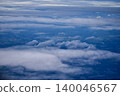 Looking through the airplane window with the view of cityscape under the clouds. Clouds above the city. Looking from aerial view. Nature and travel concept. 140046567