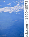 Looking through the airplane window with the view of cityscape under the clouds. Clouds above the city. Looking from aerial view. Nature and travel concept. 140046573