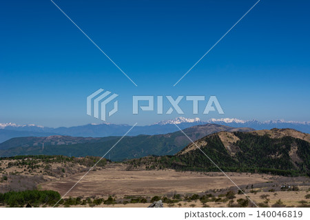 A breathtaking view of the clear blue sky, the golden Yashimagahara Marshland, and the snow-capped Northern Alps mountain range shining in the distance. A breathtaking view of the clear blue sky, the golden Yashimagahara Marshland, and the snow-capped Northern Alps mountain range shining in the distance. 140046819
