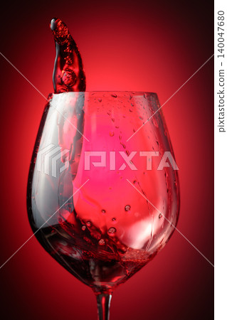 Wine glass with red liquid frozen in movement. Wine glass with red liquid frozen in movement. 140047680