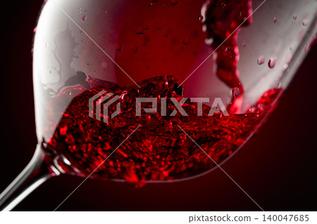Red wine is poured into a glass. Red wine is poured into a glass. 140047685