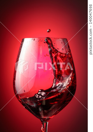 Wine glass with red liquid frozen in movement. Wine glass with red liquid frozen in movement. 140047698