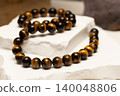 Tiger's eye stone jewelry displayed on a white surface 140048806