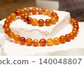 Cracked agate jewelry displayed on a white stone surface 140048807
