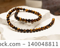 Tiger's eye stone jewelry displayed on a white surface 140048811