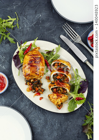 Stuffed squid cut into slices with vegetable filling. 140048923