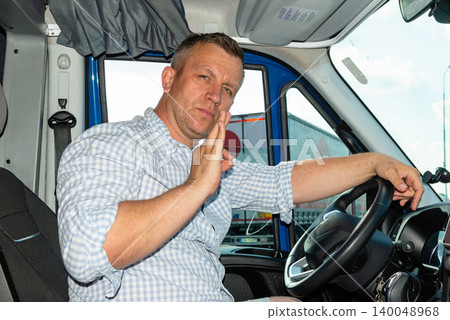 Male driver looking serious and showing hand stop sign from his cabin window. Male driver looking serious and showing hand stop sign from his cabin window. 140048968