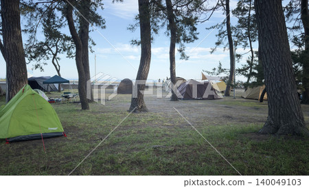 A scene of tents in the woods at a beach campsite during summer vacation. 140049103