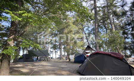 A scene of tents in the woods at a beach campsite during summer vacation. A scene of tents in the woods at a beach campsite during summer vacation. 140049104