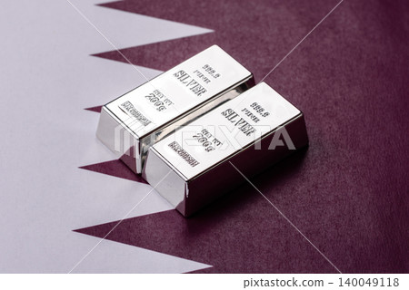 A silver bar, white metal against a backdrop of Qatari money, as a concept. A silver bar A silver bar, white metal against a backdrop of Qatari money, as a concept. A silver bar 140049118