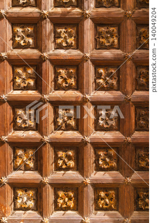 Ornate carved wooden door texture with decorative metal studs and historic craftsmanship Ornate carved wooden door texture with decorative metal studs and historic craftsmanship 140049204
