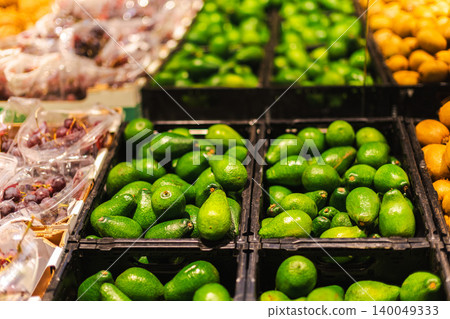 Ripe avocados in supermarket produce aisle with fresh tropical fruits and healthy grocery shopping concept in modern food store Ripe avocados in supermarket produce aisle with fresh tropical fruits and healthy grocery shopping concept in modern food store 140049333