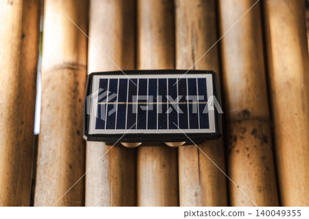 Solar powered wall light on bamboo background sustainable outdoor energy solution Solar powered wall light on bamboo background sustainable outdoor energy solution 140049355