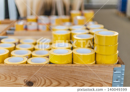 Yellow adhesive tape rolls stacked in hardware store display shelf Yellow adhesive tape rolls stacked in hardware store display shelf 140049399