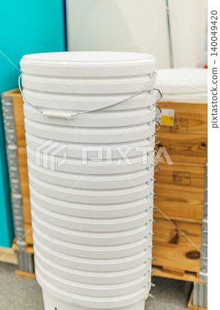 Stack of white plastic paint buckets in hardware store renovation supplies section Stack of white plastic paint buckets in hardware store renovation supplies section 140049420