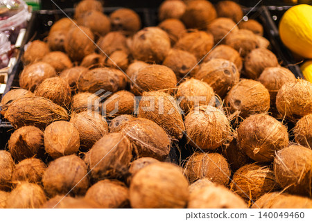 Pile of whole coconuts in grocery store produce department with tropical organic food selection and natural healthy eating concept Pile of whole coconuts in grocery store produce department with tropical organic food selection and natural healthy eating concept 140049460