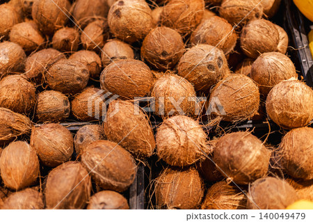 Pile of fresh coconuts at tropical food market, organic exotic fruit display and healthy natural ingredient background Pile of fresh coconuts at tropical food market, organic exotic fruit display and healthy natural ingredient background 140049479