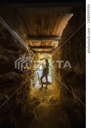 Young woman standing in cave corridor inside Aladzha Monastery Bulgaria Young woman standing in cave corridor inside Aladzha Monastery Bulgaria 140049504