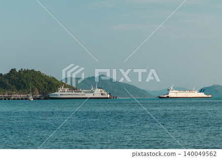 Two passenger ferries near Lipa Noi pier on Koh Samui with tropical hills in background, calm coastal transport scene in Thailand Two passenger ferries near Lipa Noi pier on Koh Samui with tropical hills in background, calm coastal transport scene in Thailand 140049562
