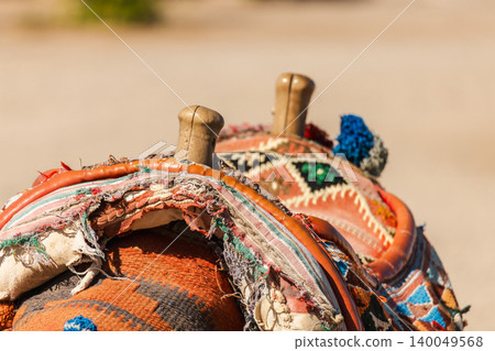 Traditional colorful camel saddle with textile decoration used for tourist rides in desert Egypt Traditional colorful camel saddle with textile decoration used for tourist rides in desert Egypt 140049568