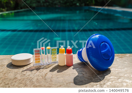 Pool water testing kit, chemical reagent bottles, chlorine tablet, and floating dispenser on pool edge for swimming pool maintenance and water quality control Pool water testing kit, chemical reagent bottles, chlorine tablet, and floating dispenser on pool edge for swimming pool maintenance and water quality control 140049576
