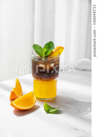 Cold bumble coffee with orange juice and ice on marble background Cold bumble coffee with orange juice and ice on marble background 140049715