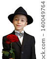 Charming little boy dressed as a gentleman in a suit and hat 140049764