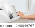 hand with red nails operating a touchscreen interface 140049767