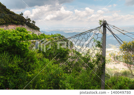 Rockfall protection barrier with steel mesh on mountain slope in Montserrat Spain Rockfall protection barrier with steel mesh on mountain slope in Montserrat Spain 140049780