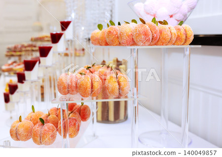 Dessert table features fruit shaped treats organized carefully for guests various sweets at event. Dessert table features fruit shaped treats organized carefully for guests various sweets at event. 140049857