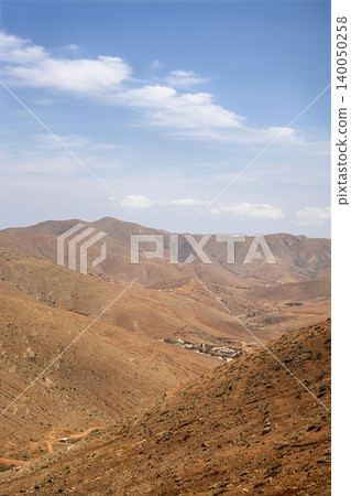 Wide view of Lanzarotes desert landscape with volcanic hills and stark island beauty 140050258