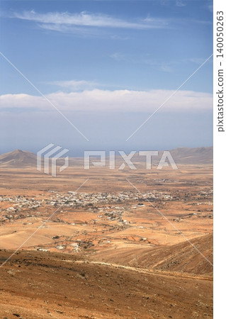 Wide view of Lanzarote desert landscape with volcanic hills and stark island beauty Wide view of Lanzarote desert landscape with volcanic hills and stark island beauty 140050263