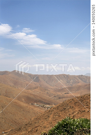 Wide view of Lanzarote desert landscape with volcanic hills and stark island beauty Wide view of Lanzarote desert landscape with volcanic hills and stark island beauty 140050265