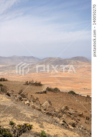 Wide view of Lanzarote desert landscape with volcanic hills and stark island beauty 140050270