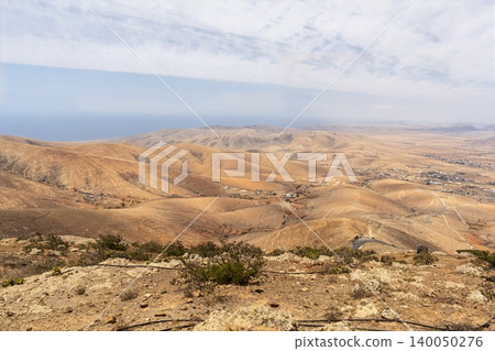Wide view of Lanzarote desert landscape with volcanic hills and stark island beauty Wide view of Lanzarote desert landscape with volcanic hills and stark island beauty 140050276