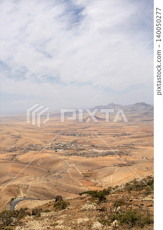 Wide view of Lanzarote desert landscape with volcanic hills and stark island beauty Wide view of Lanzarote desert landscape with volcanic hills and stark island beauty 140050277