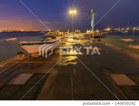 Fishing boat moored on a harbor pier at night in Cascais, Portugal. Fishing boat moored on a harbor pier at night in Cascais, Portugal. 140050292