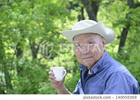 An elderly person living in the countryside enjoying forest bathing 140050369