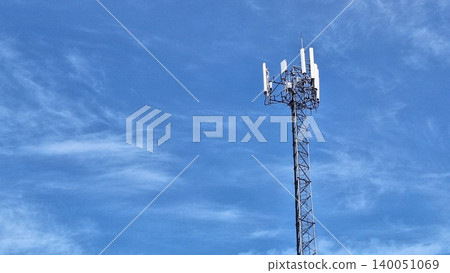 Real outdoor photograph of a cellular communication tower under blue sky with soft clouds and technology concept. Real outdoor photograph of a cellular communication tower under blue sky with soft clouds and technology concept. 140051069