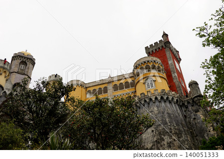 Beautiful colorful Pena Palace surrounded by green trees in Sintra, Portugal Beautiful colorful Pena Palace surrounded by green trees in Sintra, Portugal 140051333