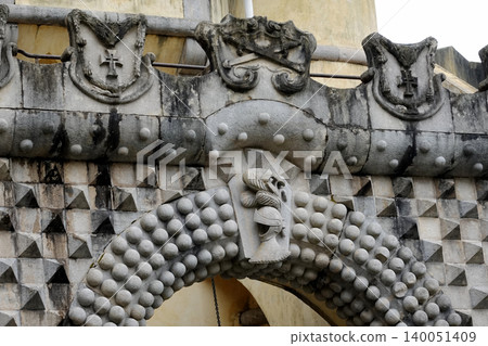 Close up of architectural stone carvings and symbols on the wall of Pena Palace in Sintra, Portugal Close up of architectural stone carvings and symbols on the wall of Pena Palace in Sintra, Portugal 140051409