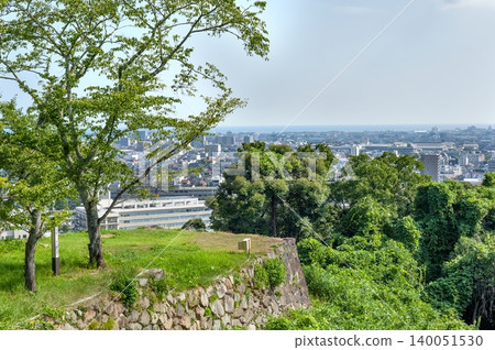 The city of Yonago, viewed through the high stone walls remaining at the guardhouse site of Yonago Castle and the lush green trees (Yonago City, Tottori Prefecture) The city of Yonago, viewed through the high stone walls remaining at the guardhouse site of Yonago Castle and the lush green trees (Yonago City, Tottori Prefecture) 140051530