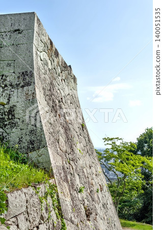 The magnificent, high stone walls of the Yonago Castle ruins, featuring beautifully curved, uchikomi-tsugi (fitted stone) construction, form the castle tower base (Yonago City, Tottori Prefecture). The magnificent, high stone walls of the Yonago Castle ruins, featuring beautifully curved, uchikomi-tsugi (fitted stone) construction, form the castle tower base (Yonago City, Tottori Prefecture). 140051535