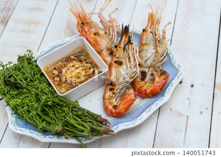 Grilled river prawns served spicy seafood dipping sauce fresh vegetables rustic plate Traditional seafood cuisine rich flavor freshness Grilled river prawns served spicy seafood dipping sauce fresh vegetables rustic plate Traditional seafood cuisine rich flavor freshness 140051743