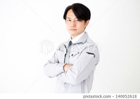 身穿灰色工作服的中年商務人士，背景為白色。 140052618