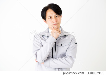 A middle-aged businessman in gray work clothes, looking troubled, against a white background. A middle-aged businessman in gray work clothes, looking troubled, against a white background. 140052943