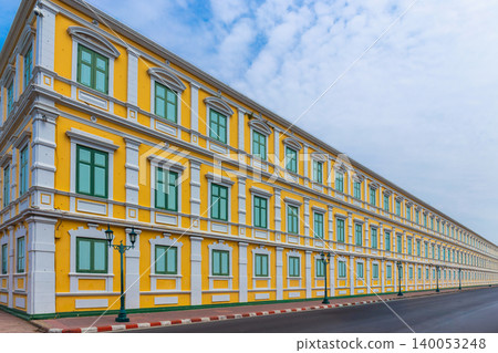 A white and yellow European-style building with many rectangular windows, against a background of the sky and with the street in front. A white and yellow European-style building with many rectangular windows, against a background of the sky and with the street in front. 140053248